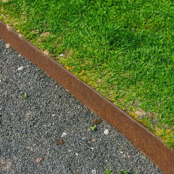 A lawn with a newly edged border separating it from gravel.